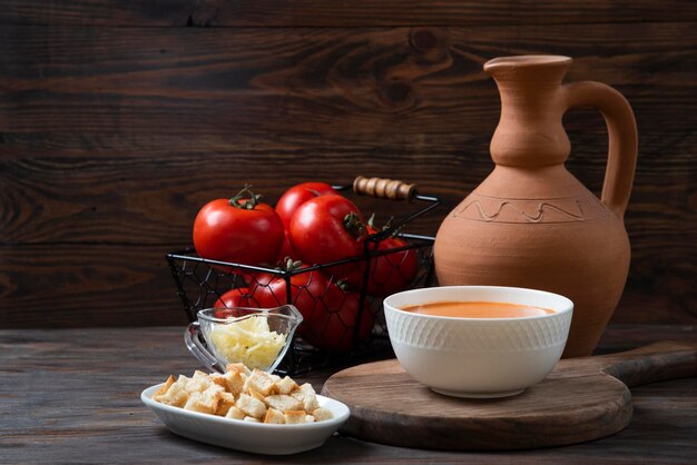 Tomatensoep op houten bord met garnier