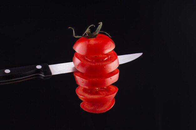 Photo tomato in the air cut with a knife