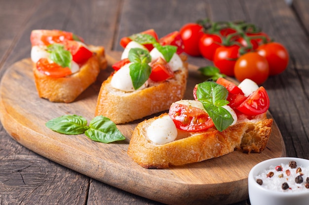 Tomato, basil and cheese fresh made caprese bruschetta. Italian tapas, antipasti with vegetables, he