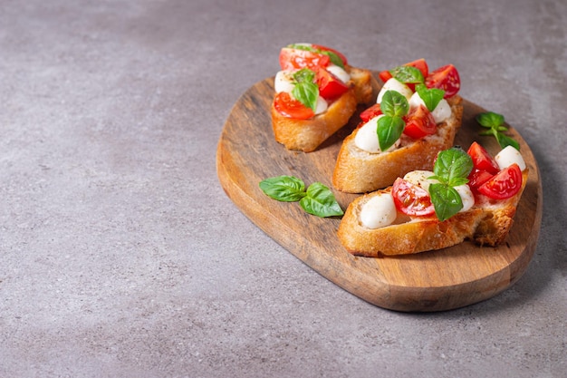 Tomato, basil and cheese fresh made caprese bruschetta. Italian tapas, antipasti with vegetables, he