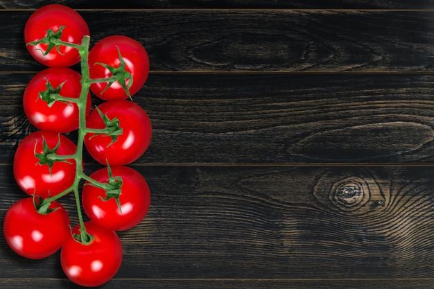 텍스트를 넣을 수 있는 어두운 나무 배경의 토마토 지점