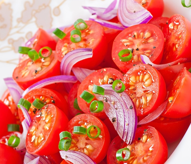 Foto insalata di pomodori ciliegia con pepe nero e cipolla