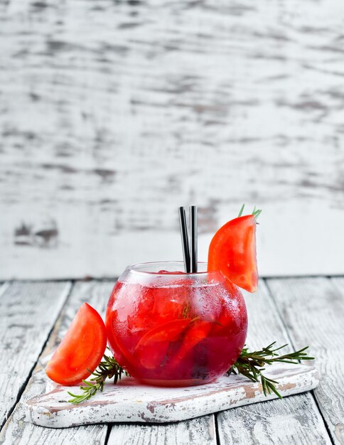 Tomato cocktail Gin cranberry juice tomatoes ice On a wooden background Top view