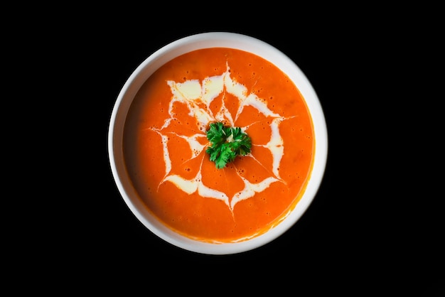 Tomato cream soup on black background