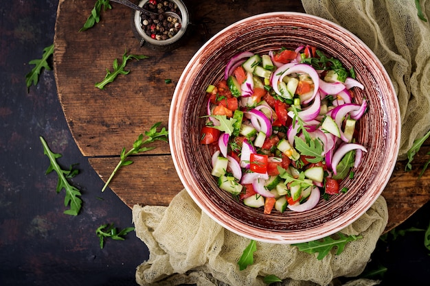 Tomato, cucumber and red onion salad with black pepper and arugula