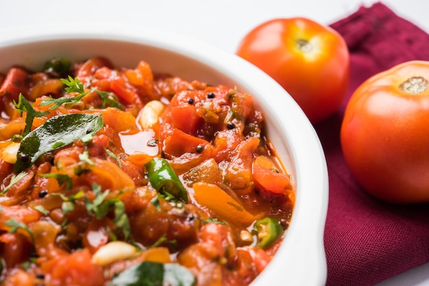 사진 sabji 또는 chutney라고도 알려진 tomato curry 또는 sabzi는 메인 코스로 인기 있는 인도 야채 메뉴인 그릇에 제공됩니다. 선택적 초점