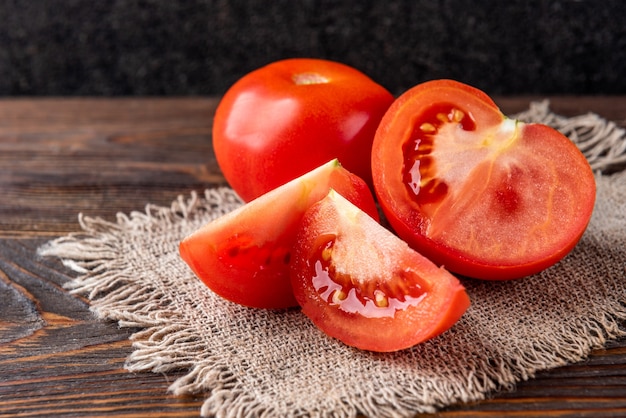 Tomato on dark wooden table.