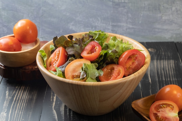 Tomato and green oak lettuce salad on bowl