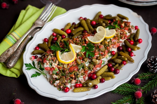 Photo tomato, herb, nut and gherkin cod fish