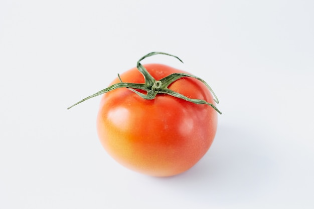 Pomodoro isolato su uno sfondo bianco, primo piano di pomodoro