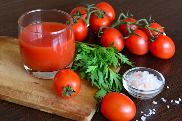 tomato juice in drinking glass with cherry tomatoes and parsley, close-up