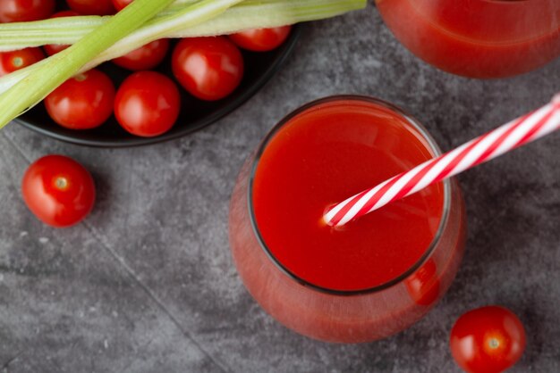 Foto succo di pomodoro in bicchiere pomodori freschi e sedano verde