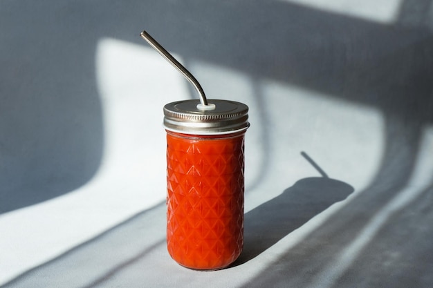 Tomato juice in glass with metal straw