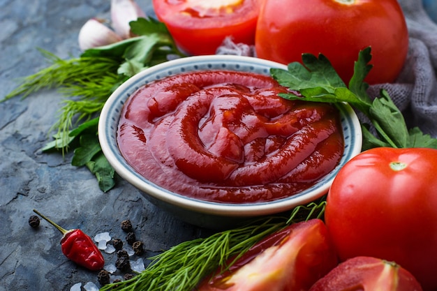 Tomato ketchup sauce on concrete background. Selective focus