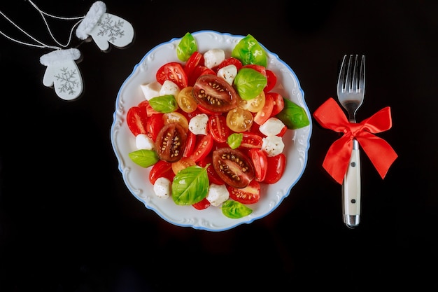 Tomato and mozzarella salad with fork for Christmas dinner.