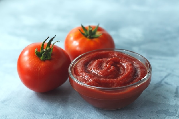 Tomato paste from fresh tomatoes on gray background