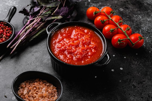 Tomato puree set, on black dark stone table background