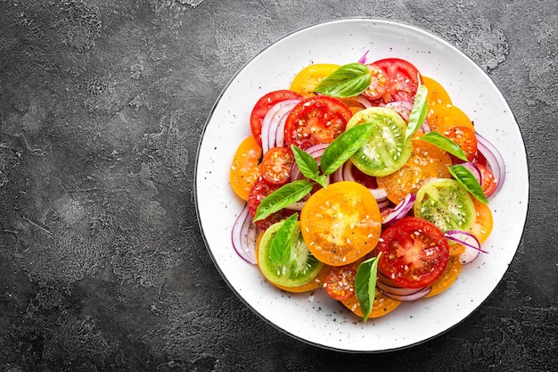 Tomato salad Fresh vegetable salad with tomatoes onion and basil