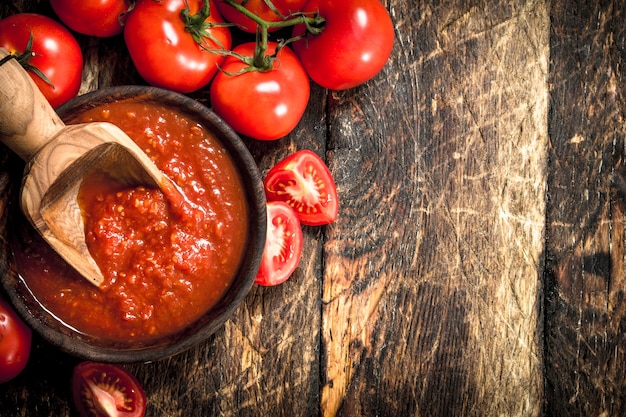 Tomato sauce in a bowl. On wooden background.