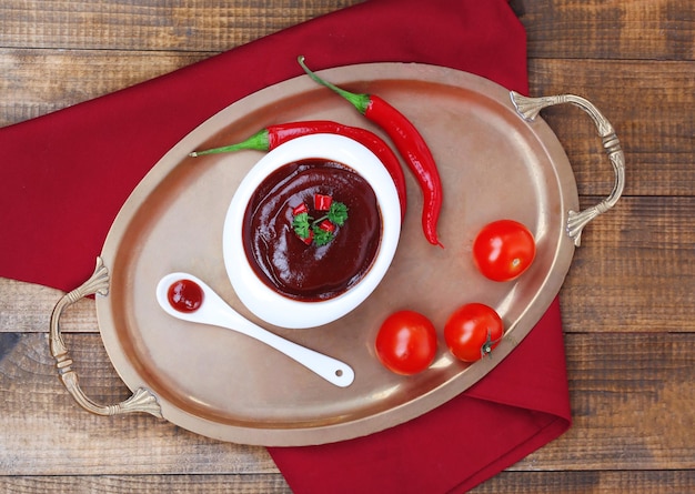 Tomato sauce in bowl on wooden table closeup