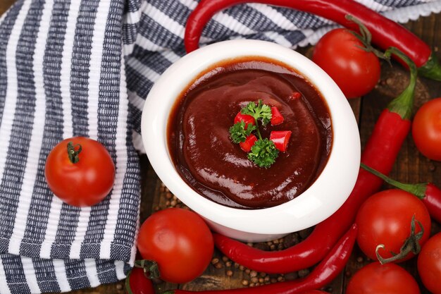 Tomato sauce in bowl on wooden table closeup