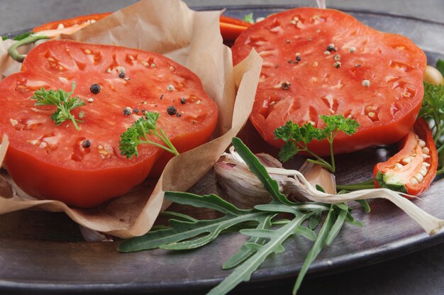 Tomato sauce and ingredients for its cooking on metal dish.