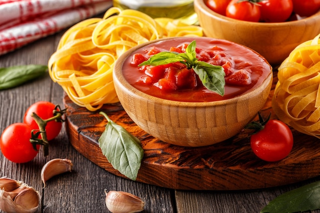 Salsa di pomodoro, pasta, pomodori, aglio, olio d'oliva sul legno vecchio.