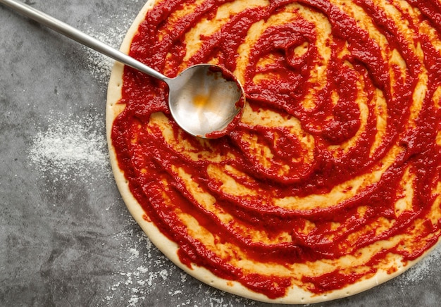 Foto salsa di pomodoro sulla disposizione della pizza