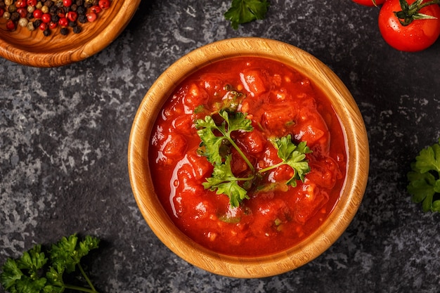 Salsa di pomodoro con aglio e prezzemolo in una ciotola di legno