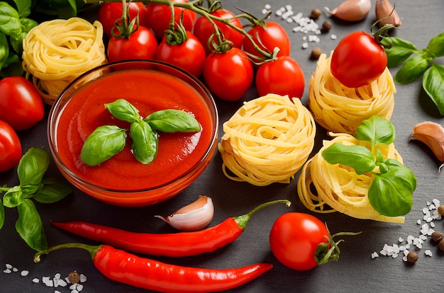 Tomato sauce with pasta on black background.