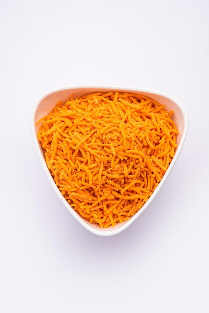 Photo tomato sev is a crispy crunchy orange colored flavored fried farsan with salt and spice powders