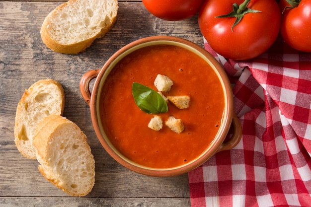 Tomato soup in brown bowl on wooden table. Top view