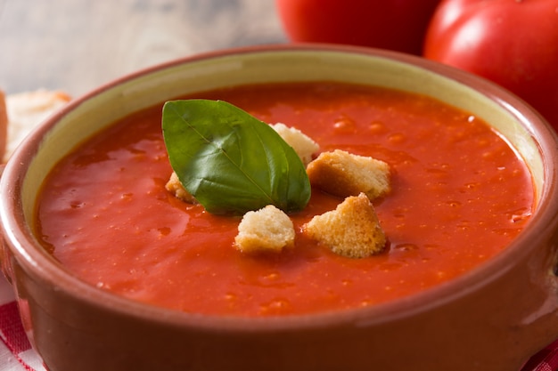 Tomato soup in brown bowl on wooden table