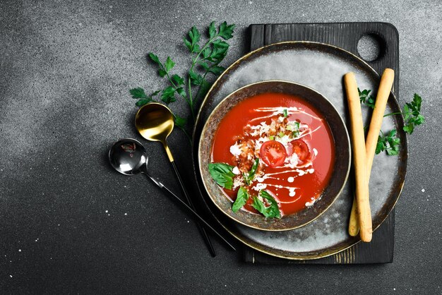 Zuppa di pomodoro con basilico e crema in una ciotola concetto di cibo sano da vicino