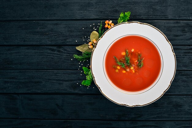 Tomato soup with chili and vegetables Healthy food On a black wooden background Top view Copy space for your text