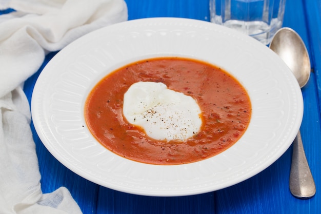 Tomato soup with egg in white plate