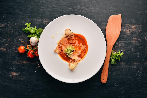 Tomato soup with Parmesan cheese and croutons of bread Top view Free space for your text On a wooden background