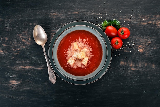 Tomato soup with Parmesan cheese. On a wooden background. Top view. Copy space.