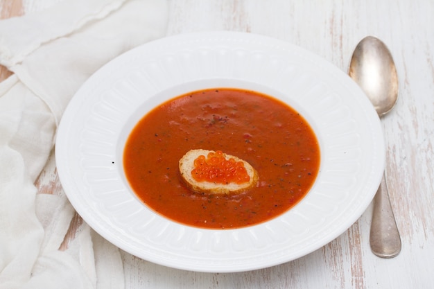 写真 白い皿にキャビアとトーストとトマトのスープ