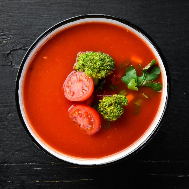 Tomato soup with vegetables and parsley. Mexican soup in a bowl. Top view.