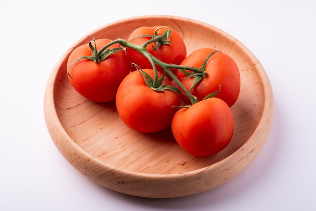 Tomato vegetables on wooden plate isolated on white