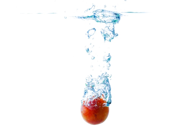 Photo tomato water splash background blur