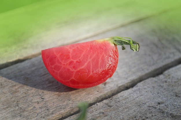 Tomato with slice on rustic wooden background Fresh cut tomato on wooden table