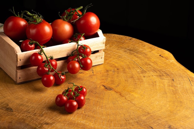 Pomodori, bellissimi pomodori disposti all'interno di una scatola di legno su legno rustico, fuoco selettivo.