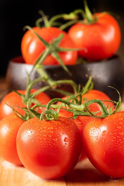 소박한 테이블 검정색 배경 선택적 초점에 나무 냄비에 배치 토마토 아름다운 토마토