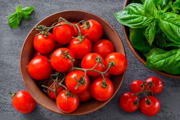 Tomatoes in bowl with basil on fabric background