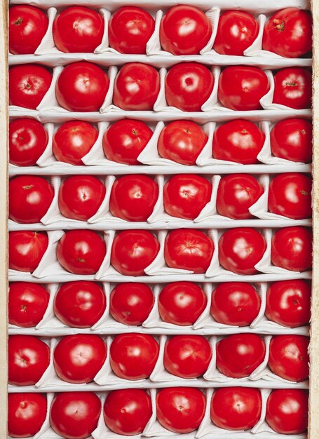 トマト ボックスのクローズ アップ完熟トマトは、販売のためのボックスに行にも並んでいます。