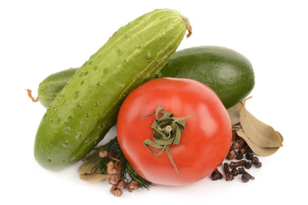 Tomatoes, cucumbers and spices on a white background