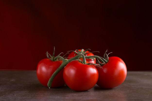  tomatoes on a dark background