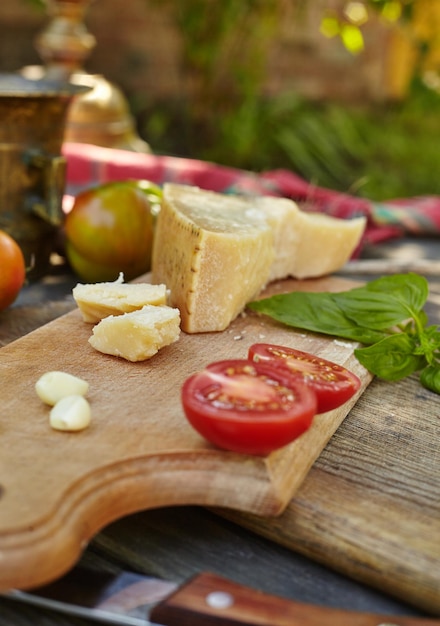 Foto pomodori aglio basilico e parmigiano di formaggio su una vecchia tavola autentica